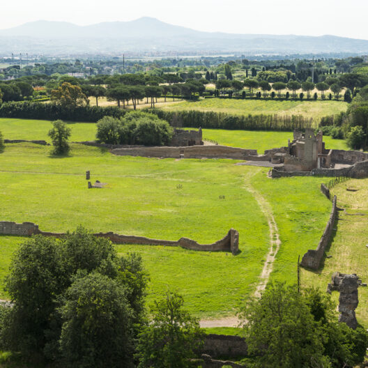 Una vista del Parco Archeologico dell'Appia Antica di Roma, con ampi prati verdi e alberi